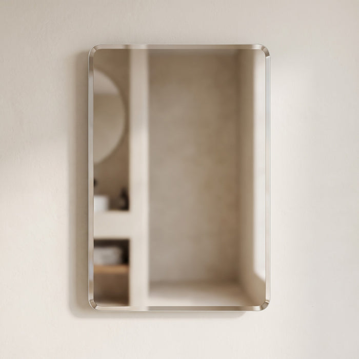 Curvelle frameless rounded-corner mirror on a warm plaster wall