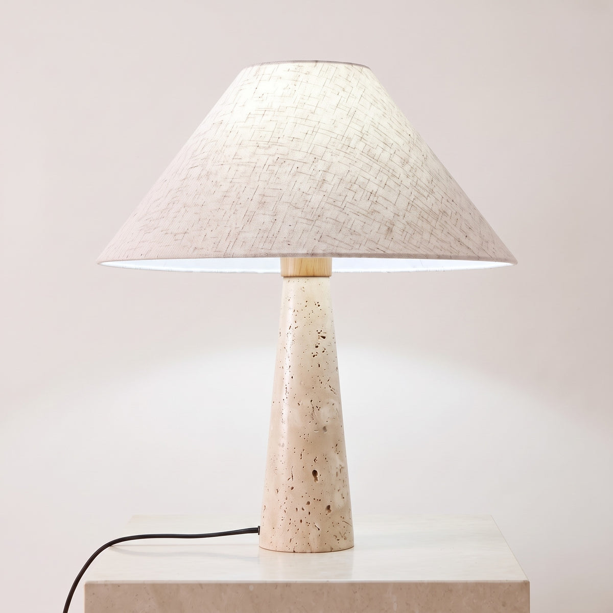 Cairnell travertine lamp lit with neutral white light