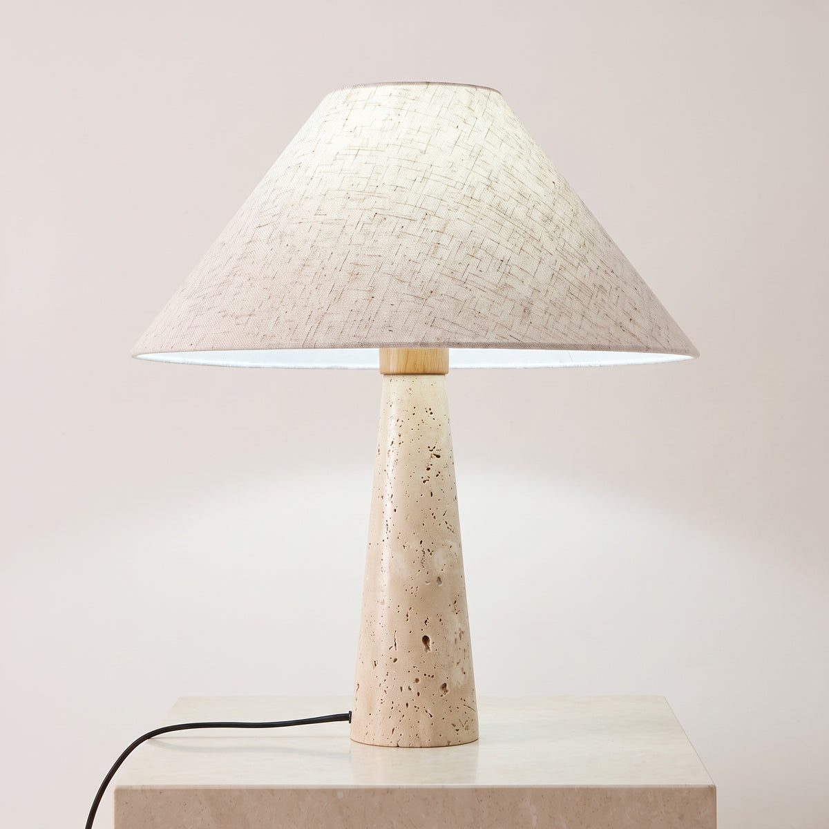 Cairnell travertine lamp lit with cool white light