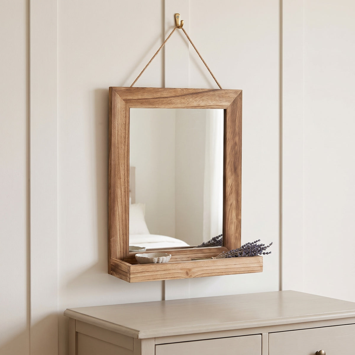 Fernley wooden hanging mirror above a chest of drawers in a bedroom