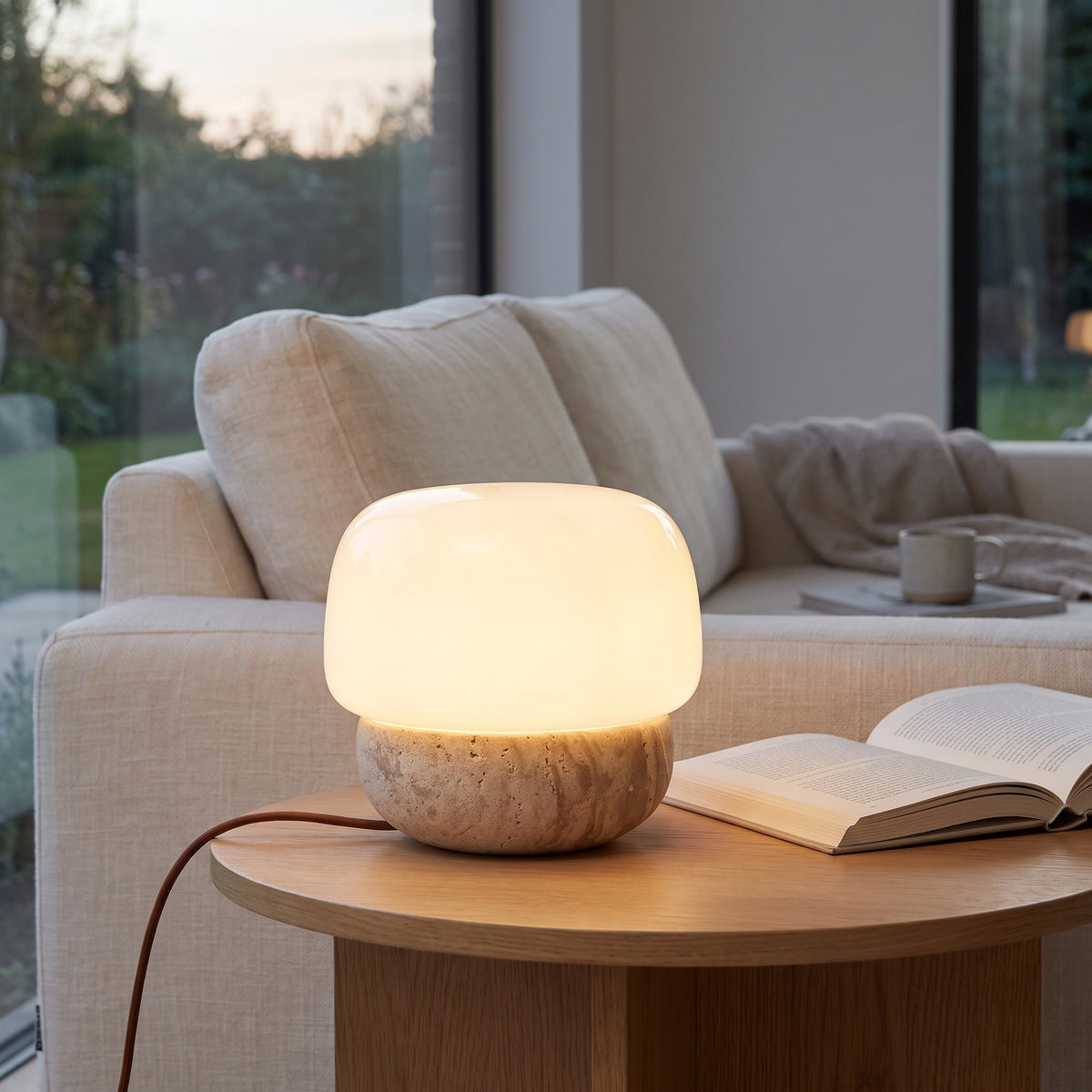 Morella travertine lamp on a side table beside a sofa