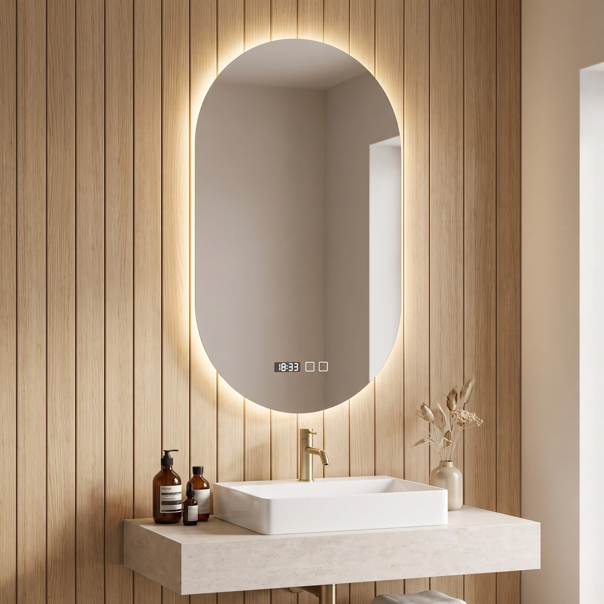 Ovelune oval LED mirror above a stone vanity with oak panelling