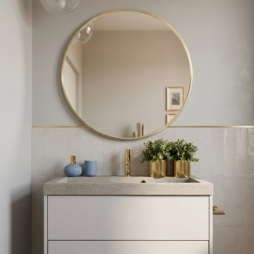 Aurelle gold round mirror above a bathroom washstand